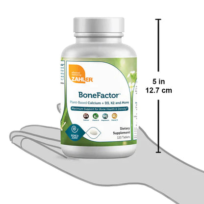 Hand holding BoneFactor calcium tablet for daily bone strength and joint support
